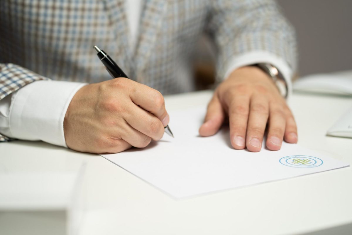 man signing document