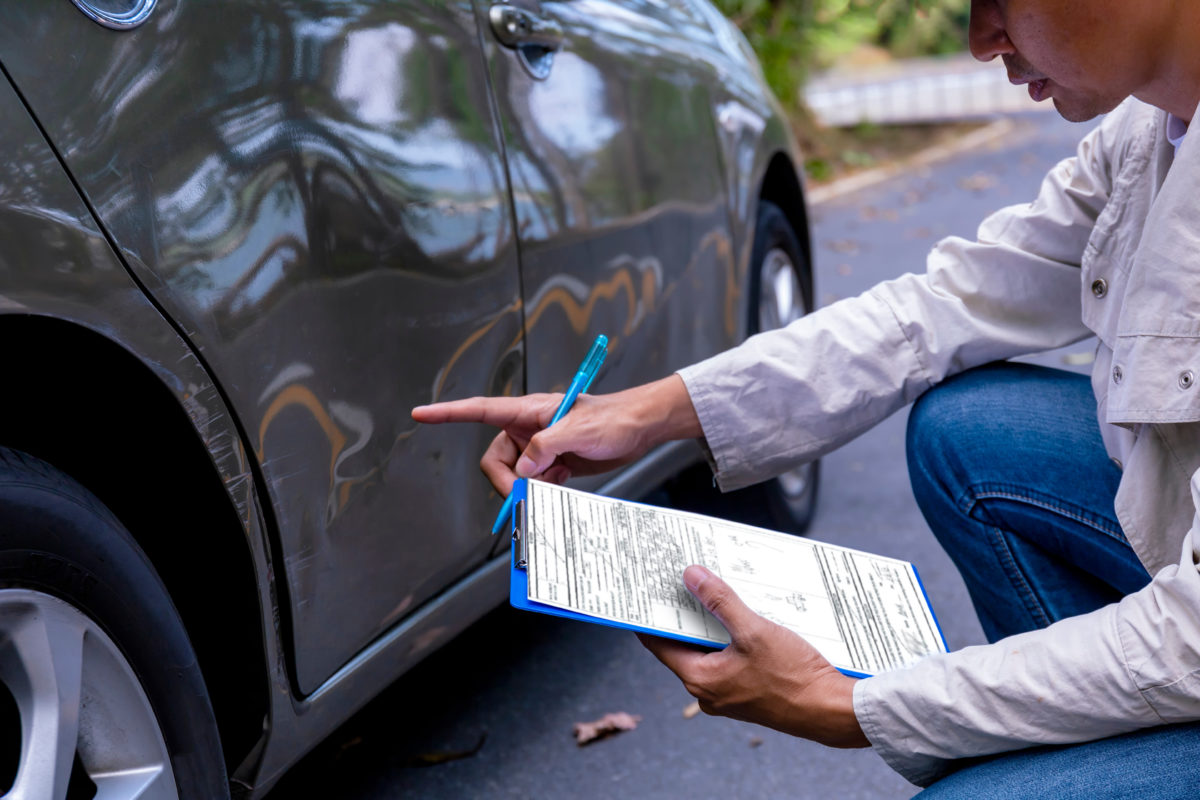 person assessing vehicle damage