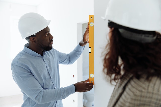 man inspecting property with level