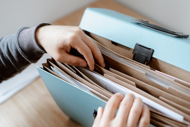 person looking through a file folder