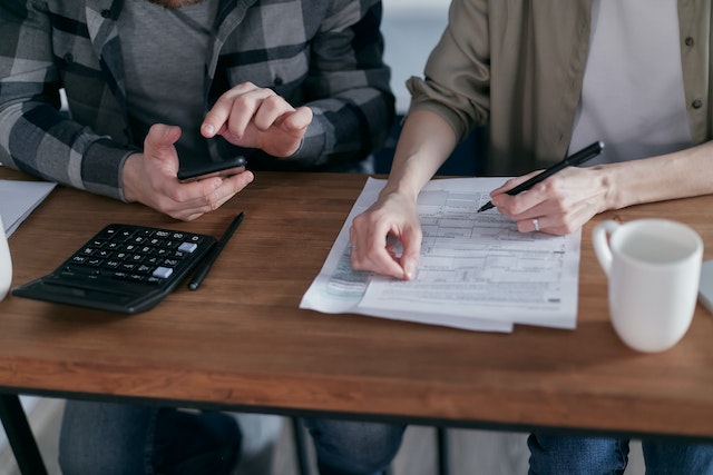 man and women looking at documents with calculator