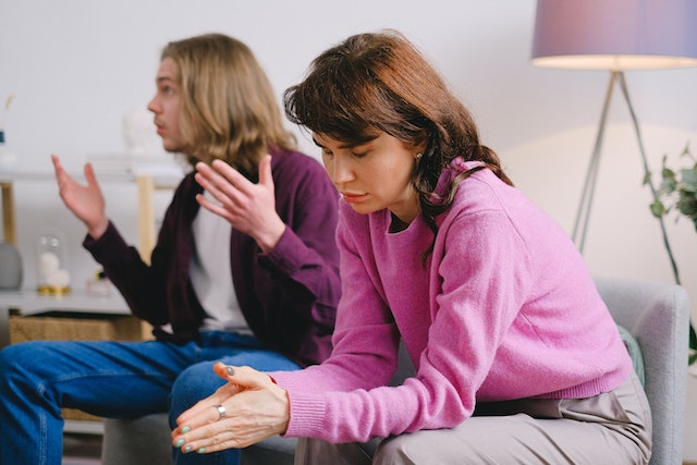 people sitting on couch arguing