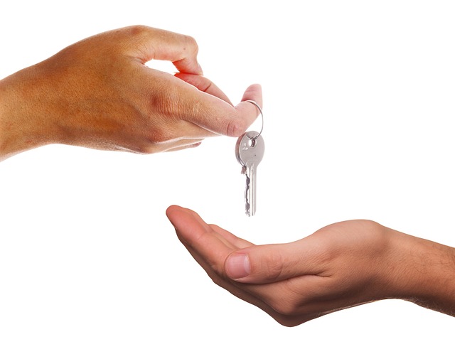 person handing key to another person