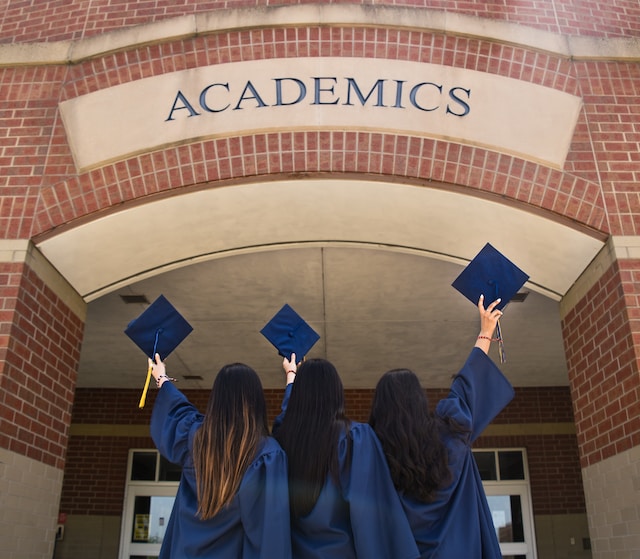 three girls holding graduation caps