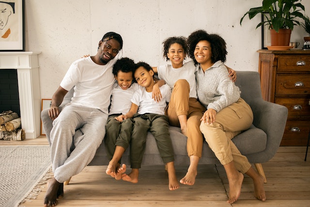 family smiling on their couch