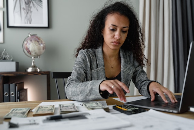 woman at desk with money and calculator