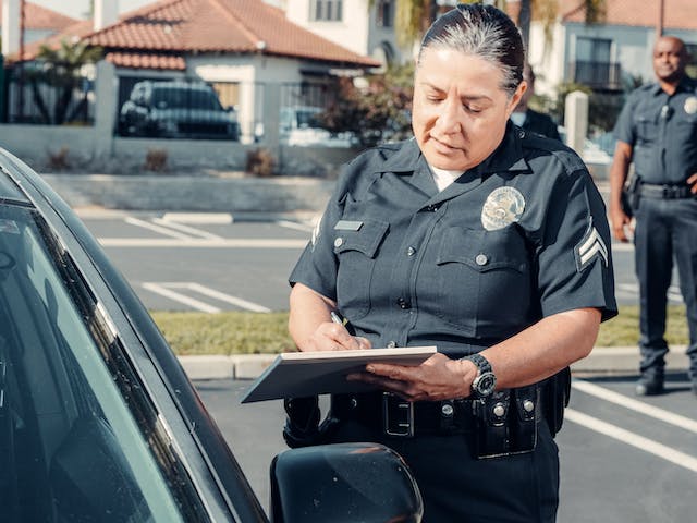 police officer taking report near car