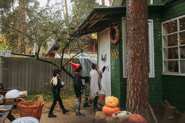 children in costume knocking on door