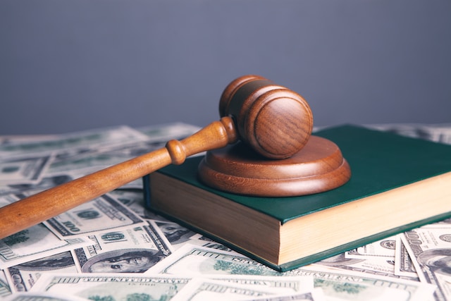 gavel on top of book and money