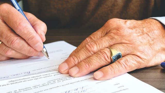 man signing document