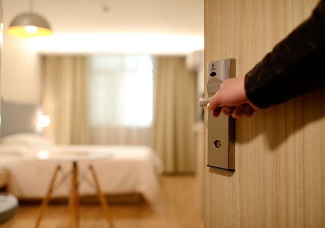 person opening door to hotel room