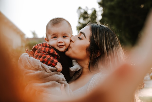 woman kissing baby on the cheek