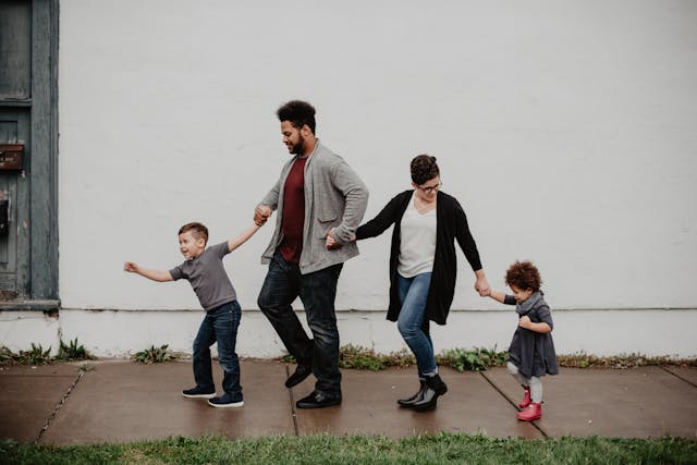 family of four holding hands