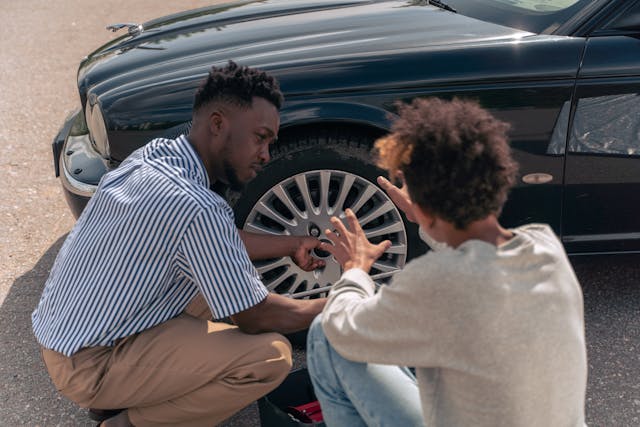 two people looking at car tire